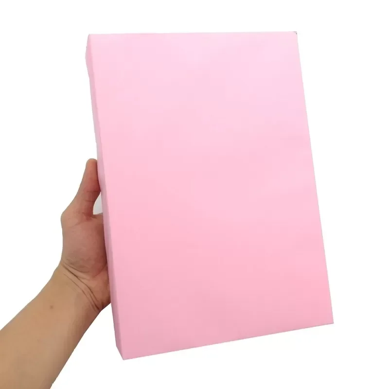 Bàn tay cầm tấm bảng với nền màu hồng phẳng.