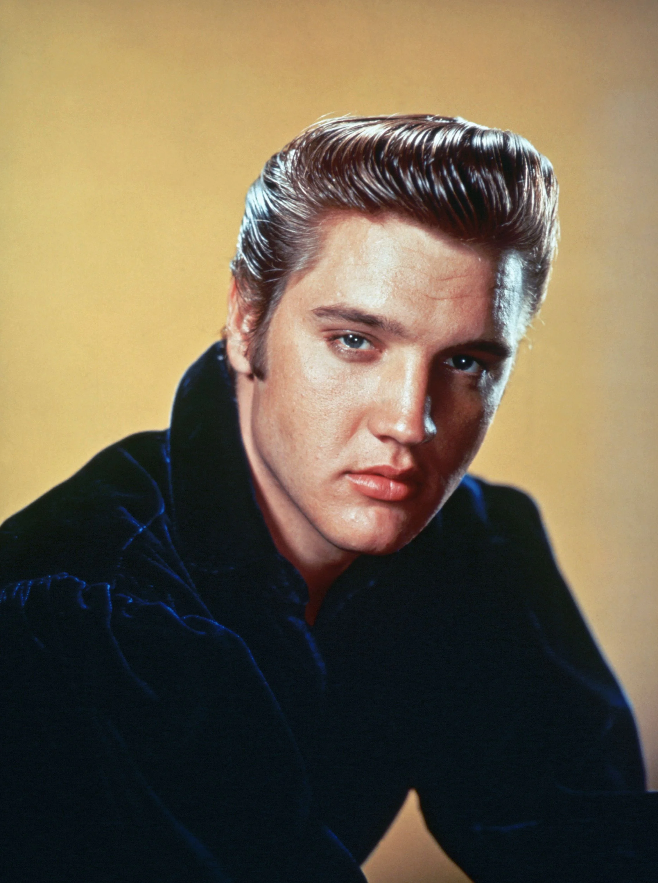 Chân dung Elvis Presley trong bộ vest tối màu trên nền vàng