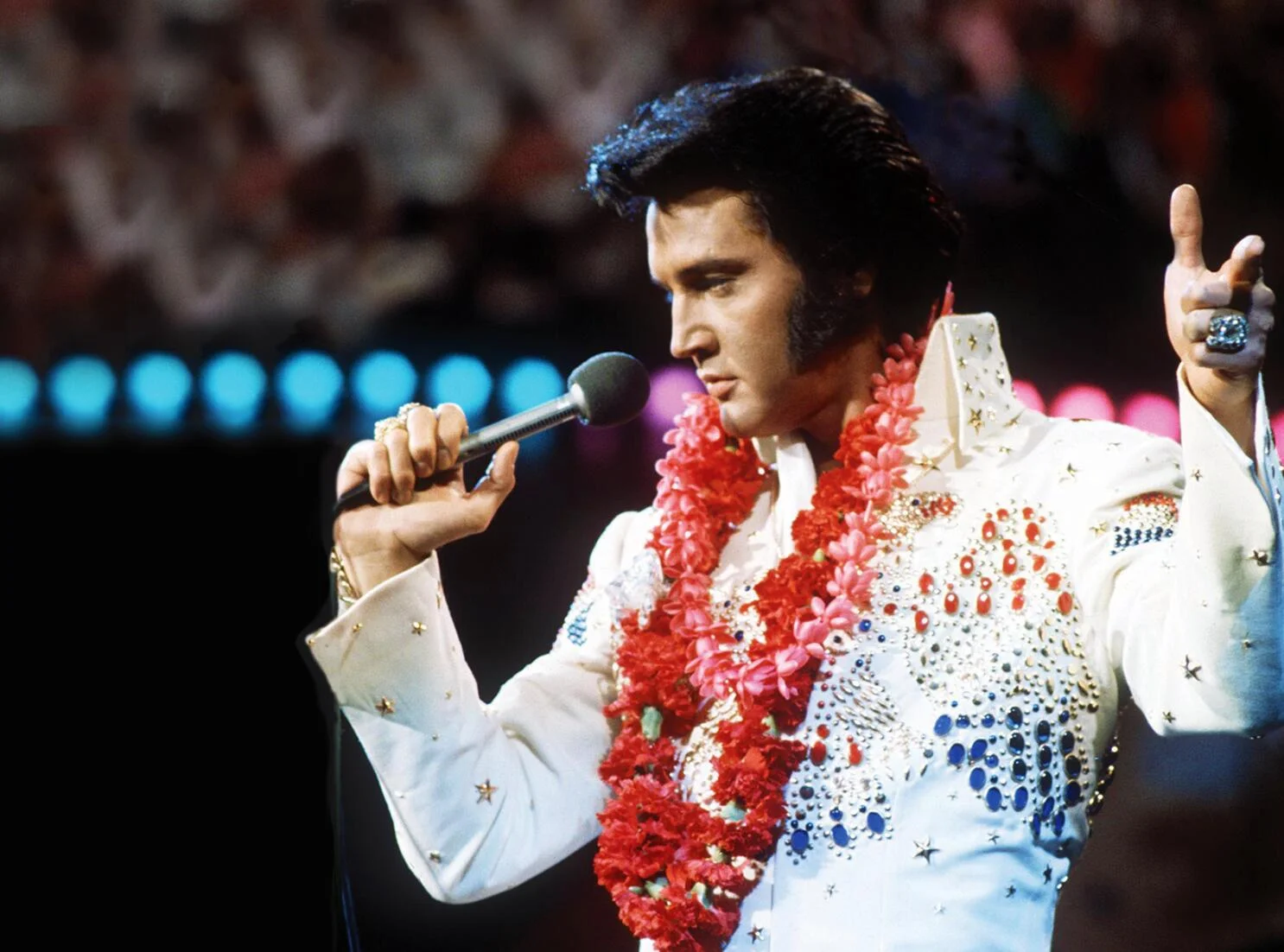 Elvis Presley hát trên sân khấu với vòng hoa