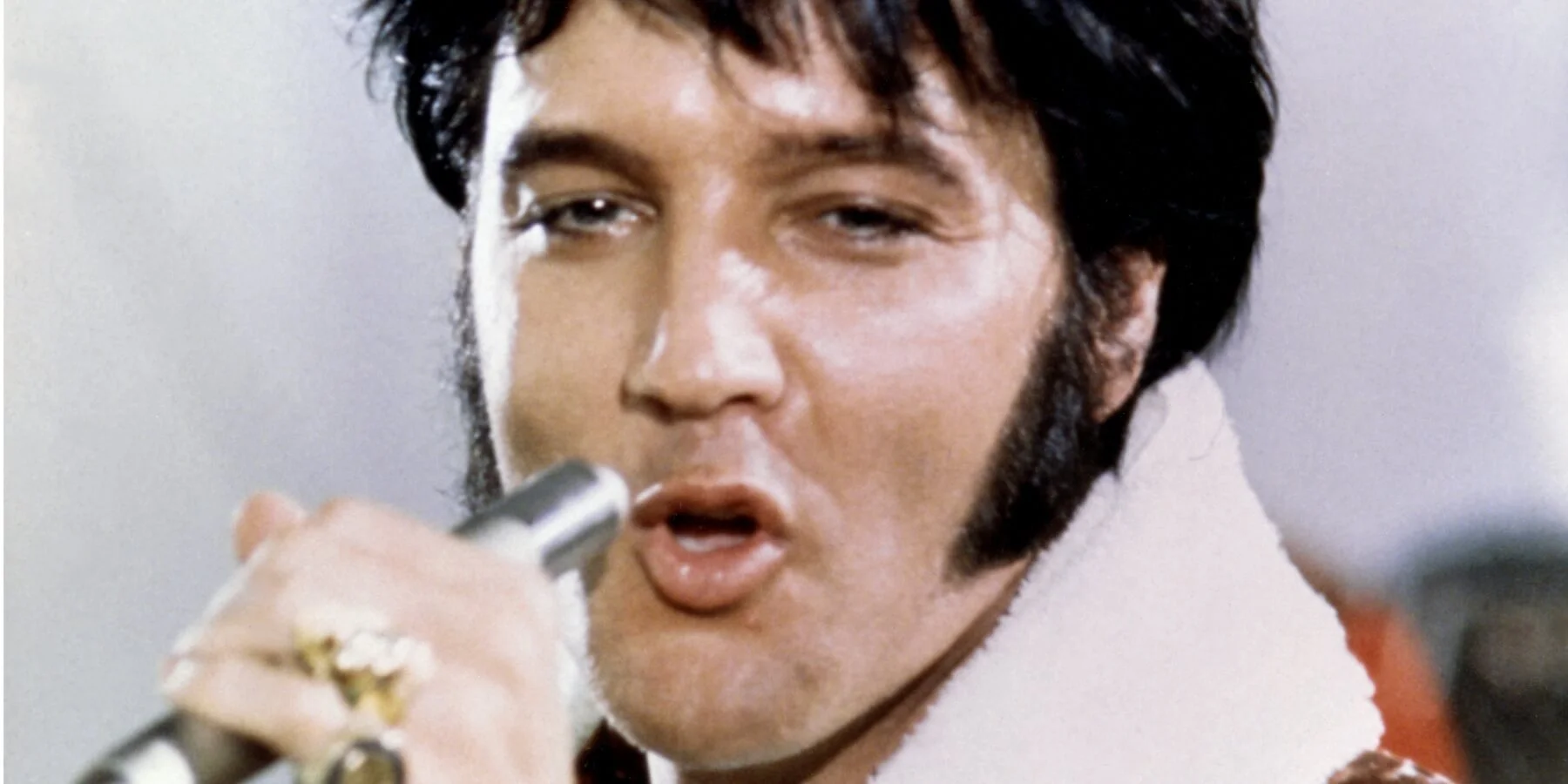 Ảnh chân dung Elvis Presley đang hát với micro