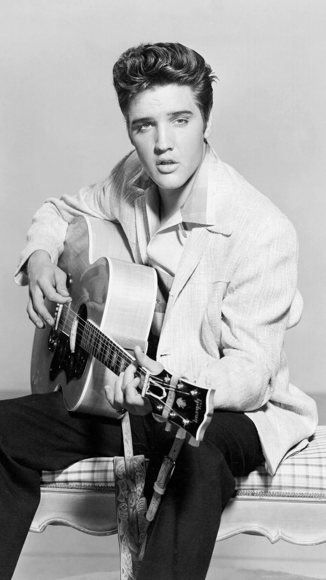 Elvis Presley ngồi chơi guitar trong ảnh đen trắng