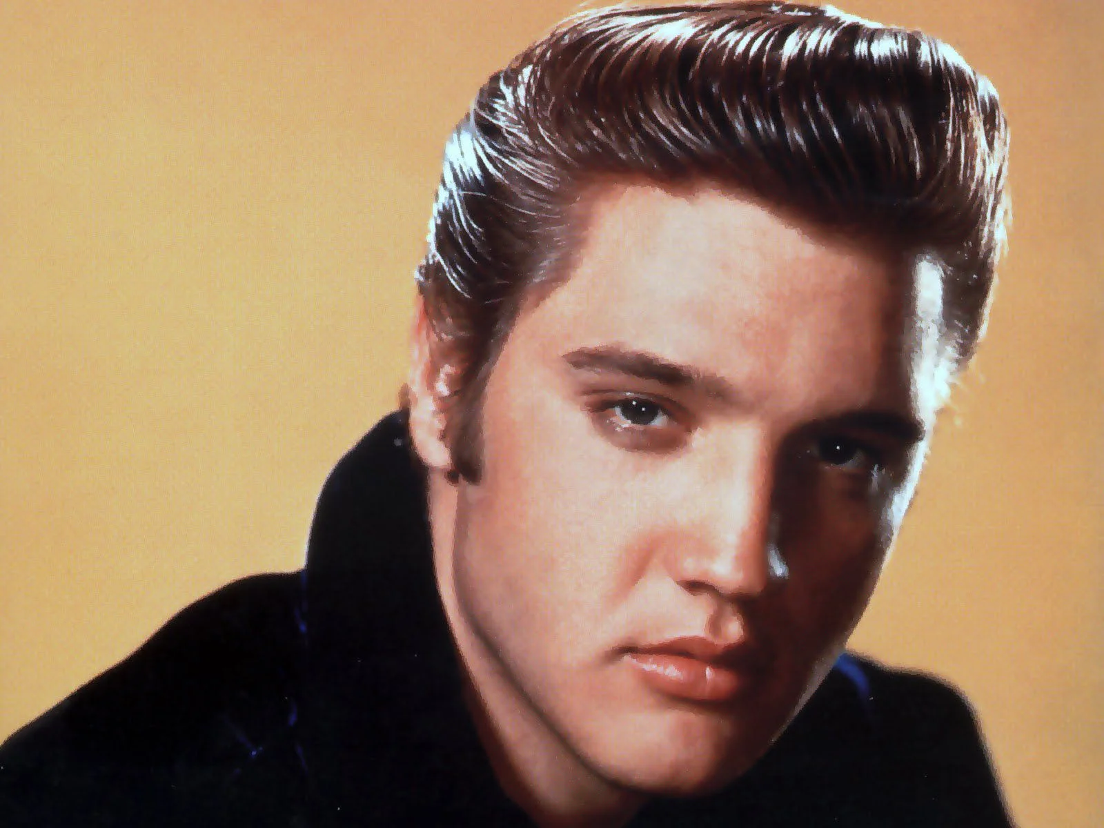 Ảnh chân dung cận mặt Elvis Presley trên nền vàng
