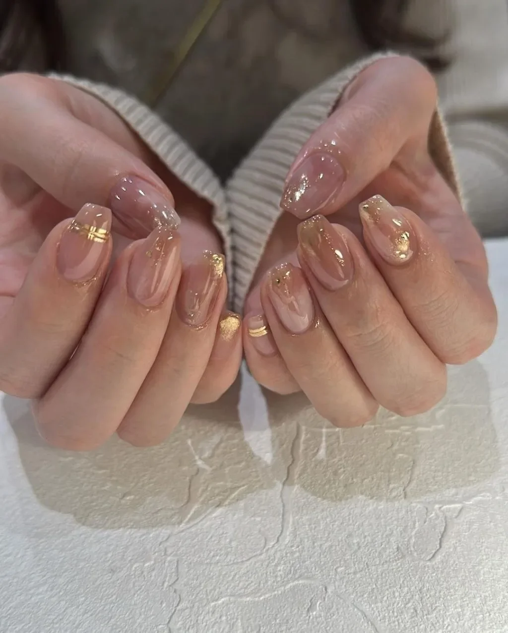 Mẫu nail đẹp màu nude trong suốt với họa tiết nhũ vàng và đá nhỏ