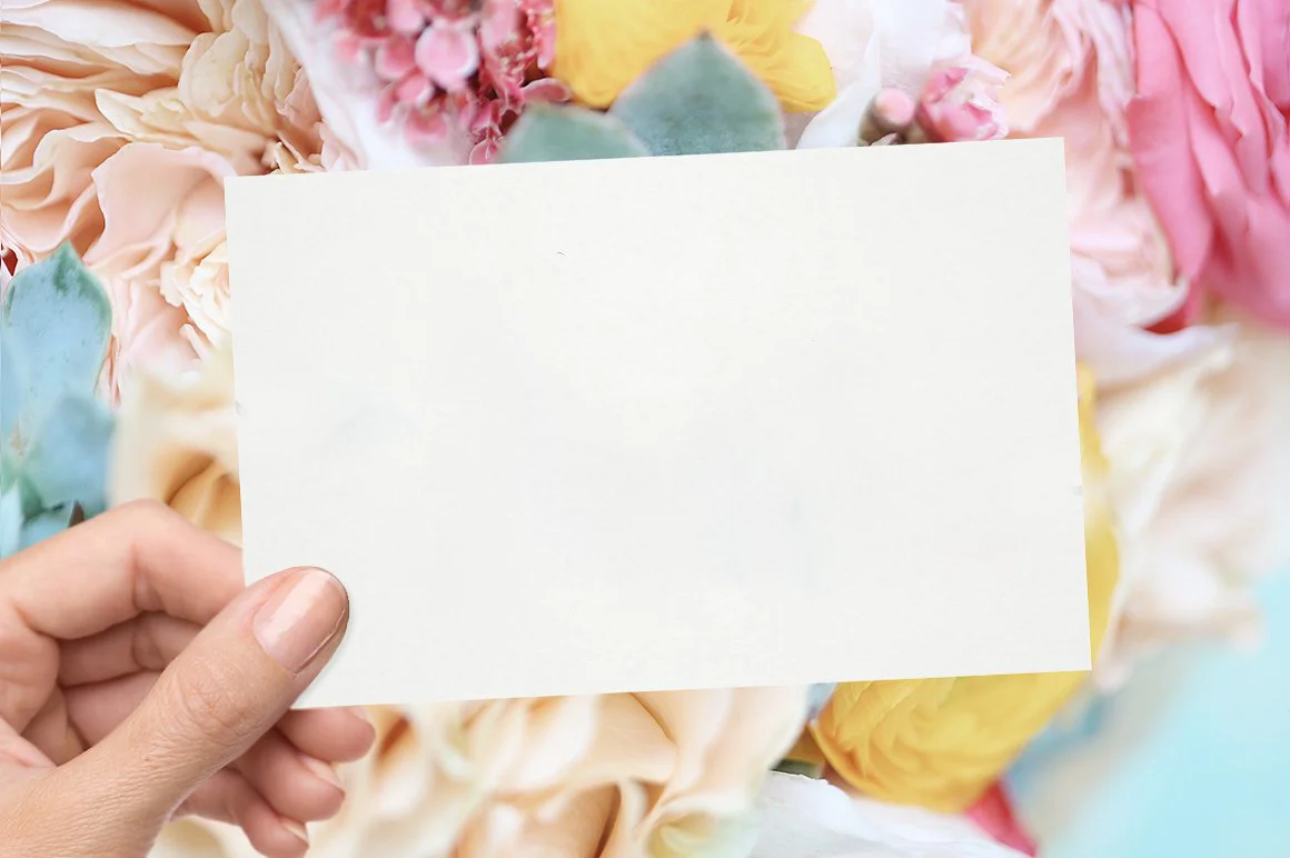 Hình nền PowerPoint hoa pastel nhiều màu với bàn tay cầm tấm thiệp trắng trống ở trung tâm