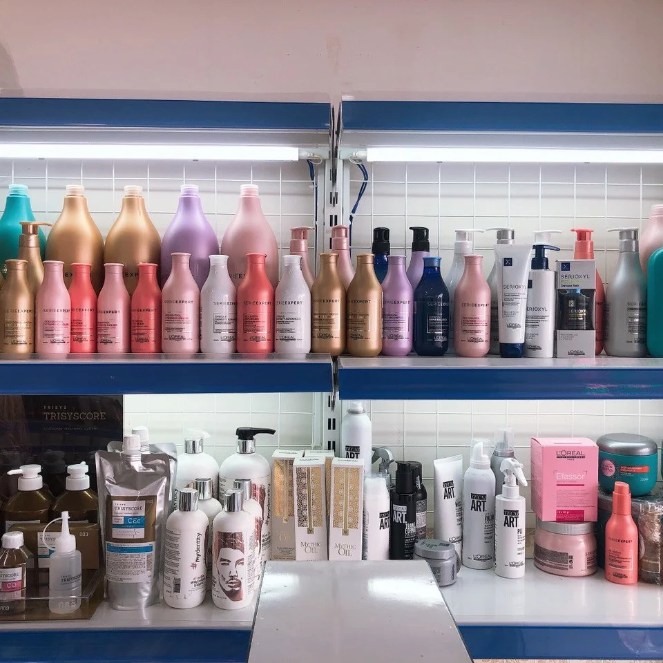 Các loại phụ liệu tóc chuyên nghiệp được trưng bày trên kệ tại salon